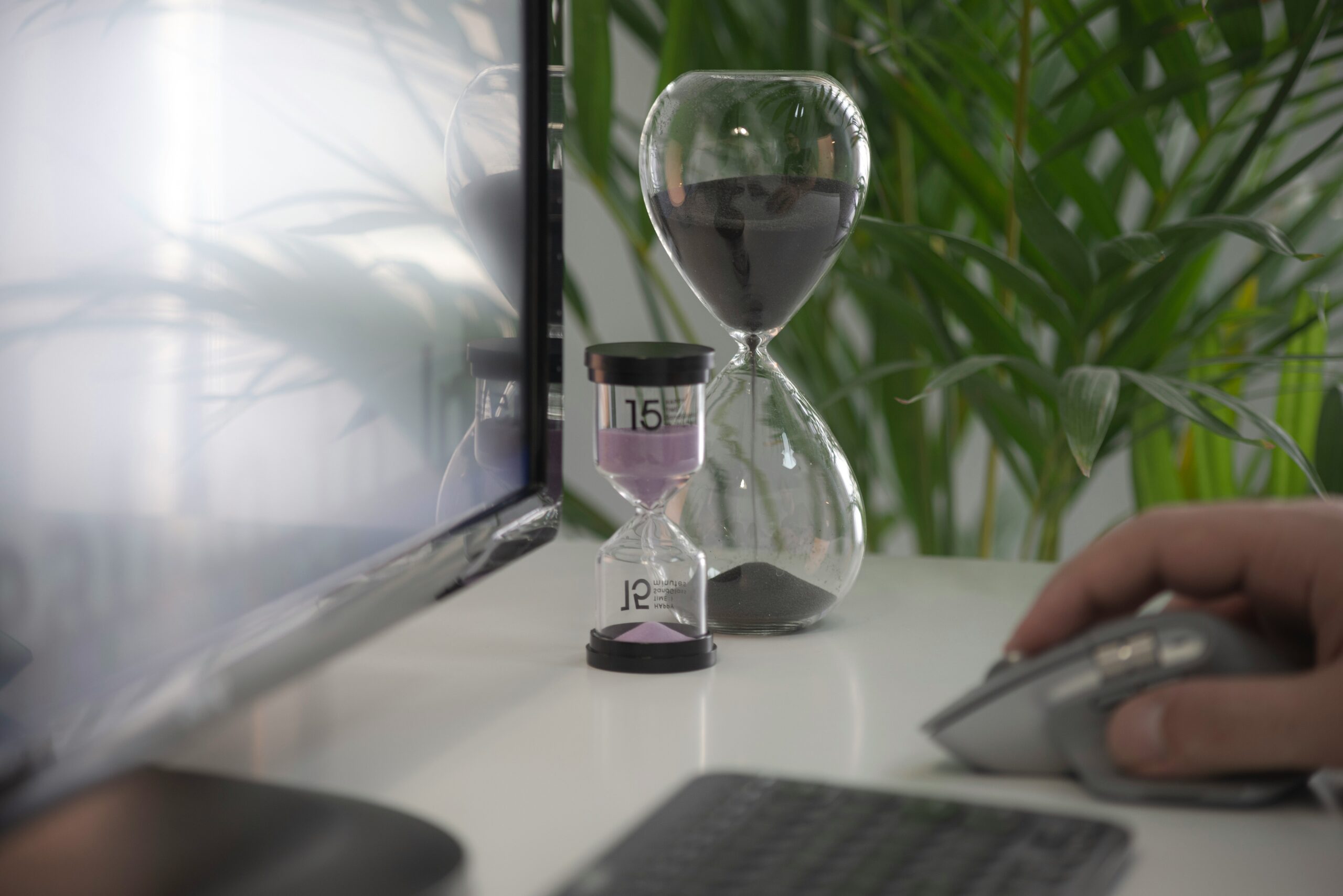 Ensuring Compliance with Maximum Working Time and Rest Periods in the EU - Computer Screen and Hourglasses on Desk